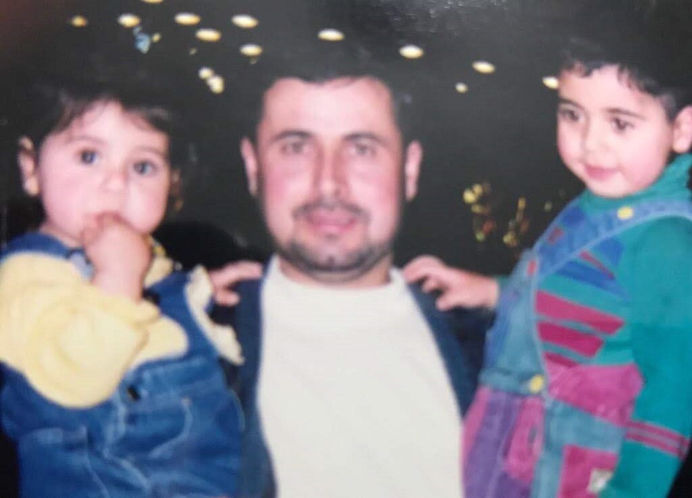 A man is posing with two small children.